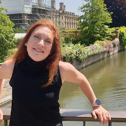 Photo of woman stood on bridge in Cambridge smiling