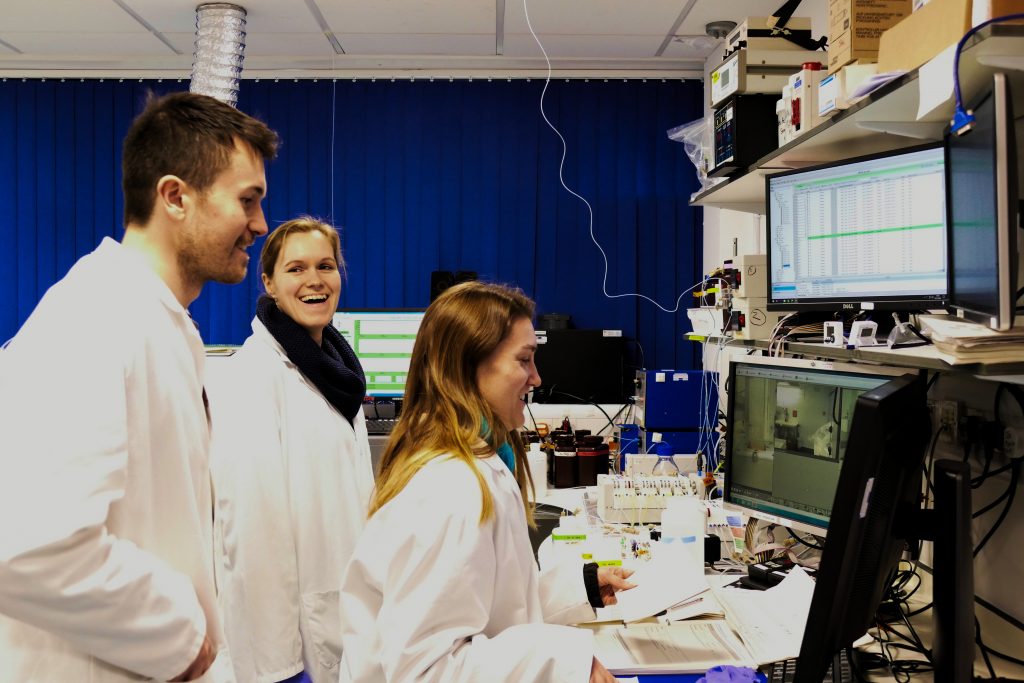 Image of three people in the lab smiling