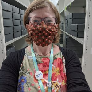 Woman standing in museum stores wearing face mask
