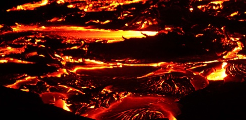 Photo of incandescent lava flow taken at night.