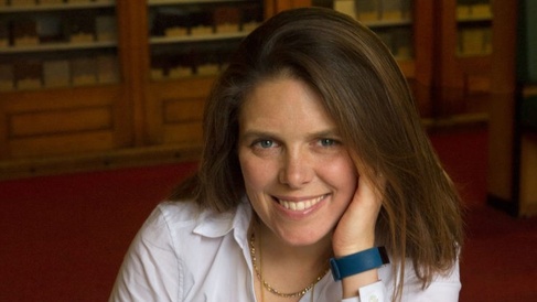 Image of a woman smiling sat at a table