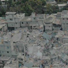 Image showing people standing amid the rubble of destroyed building