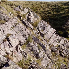 Photos shows stripey grey rocks in layers running horizontally
