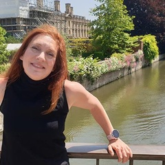 Image of a woman standing on a bridge in Cambridge smiling