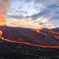 Photo of lava flowing from volcano in evening