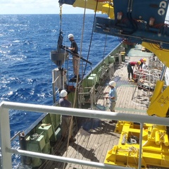 Photo of ocean drilling ship at sea, lowering down coring device to capture sediment