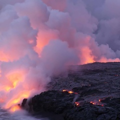 Image of lava flows in Iceland meeting the sea, with incandescent steam lofting