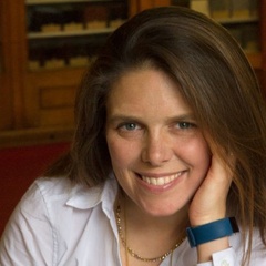 Image of a woman smiling sat at a table