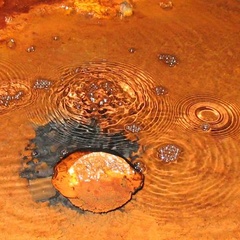 Image of rust brown water with bubbles rising 