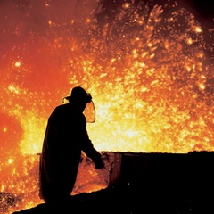 Photo of a person working at a blast furnace