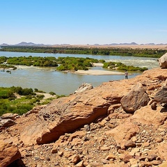 Photo showing a man standing beside the River Nile