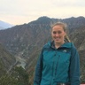 Photo of Aisling on field work, standing in front of mountains, in December 2019