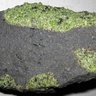 Grey volcanic rock containing exotic green nodule: you can see the pistachio green olivine crystals they are made of