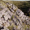 Photos shows stripey grey rocks in layers running horizontally