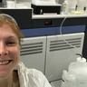 Women smiling in the lab with a mass spectrometer in the background