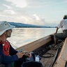 Image of two men on a boat sailing on a river