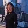 Image of a woman smiling, superimposed on an illustration of chemical symbols for magnesium