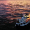 Image of sun setting behind drilling equipment on a ship