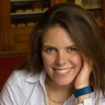 Image of a woman smiling sat at a table