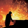 Photo of a person working at a blast furnace