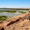 Photo showing a man standing beside the River Nile