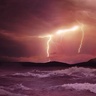 Photo of volcanic eruption with lightning and stormy sea in foreground