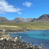 Photo taken on a beach looking up to the mountains, it is sunny