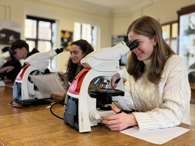 Photo of students looking down microscopes