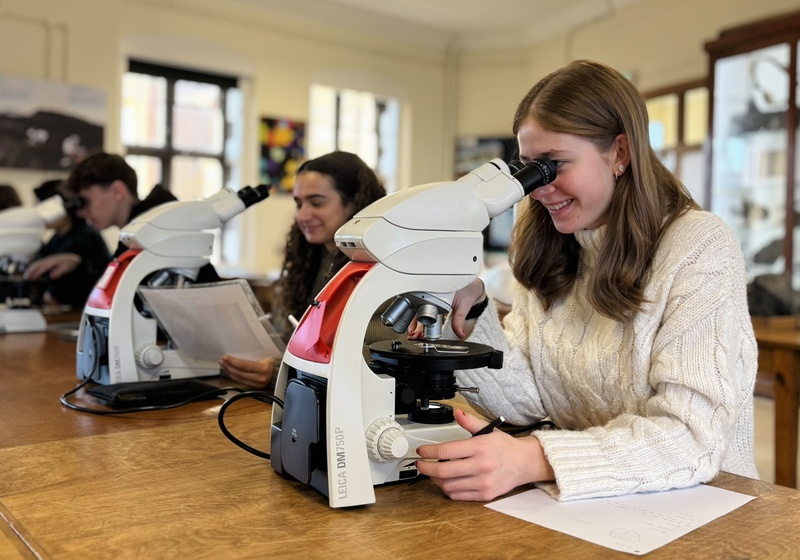 Photo of students looking down microscopes