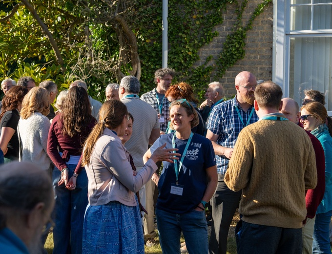 Photo showing a large group of people chatting outside