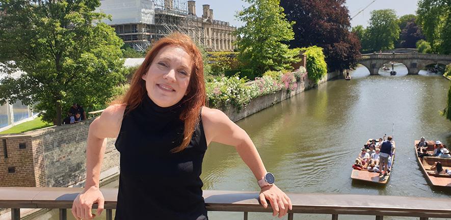 Image of a woman standing on a bridge in Cambridge smiling