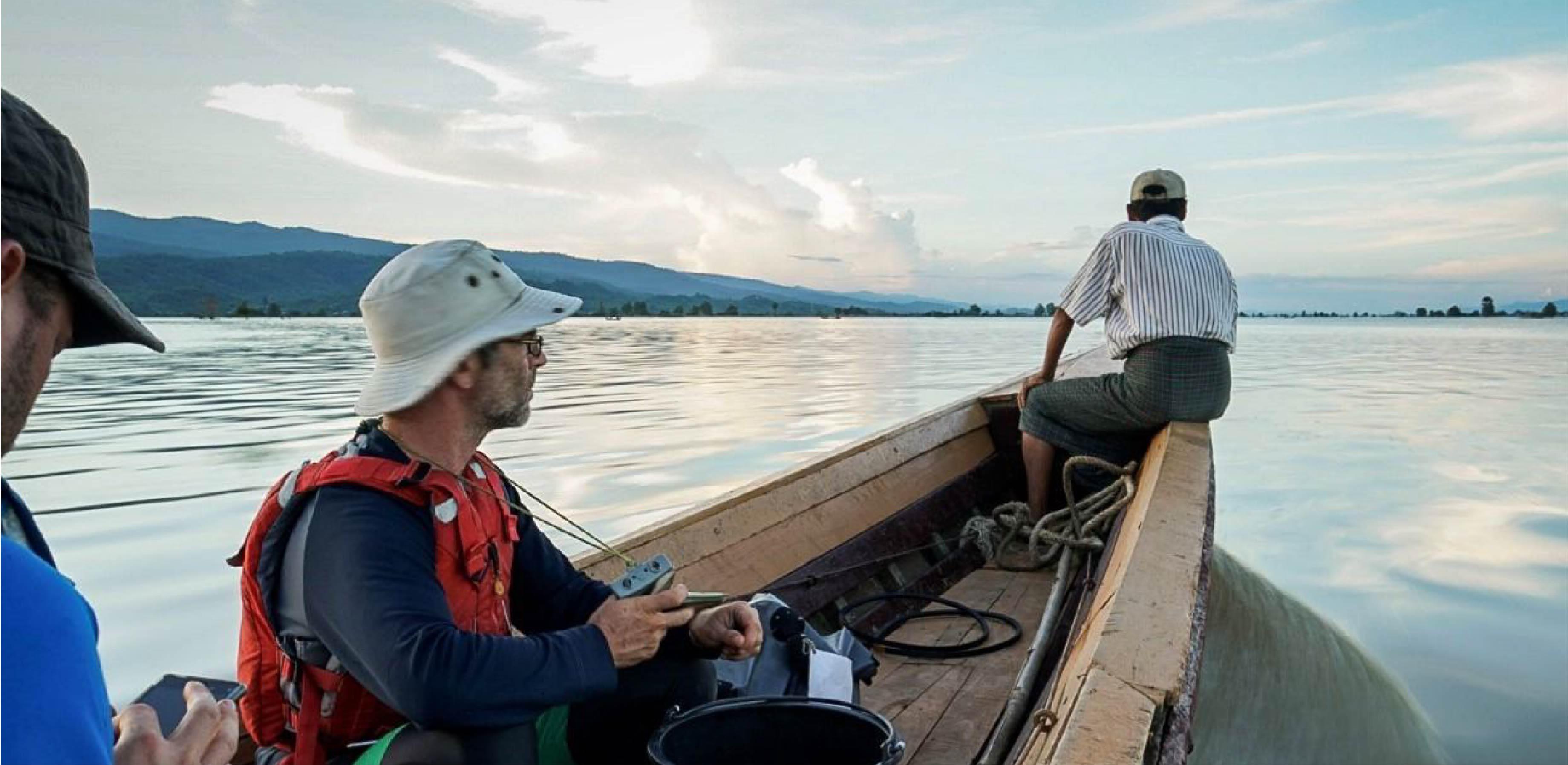 Image of two men on a boat sailing on a river