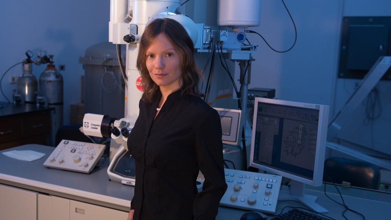 Image of a woman smiling, superimposed on an illustration of chemical symbols for magnesium