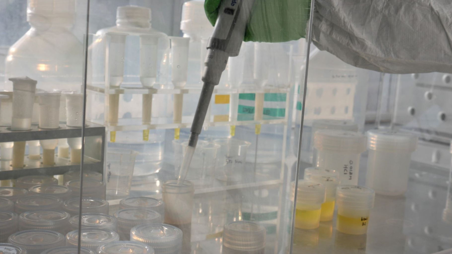Close up of sample containers and pipette in fume cupboard