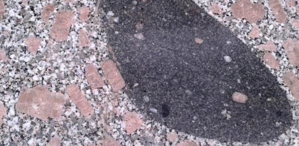 The distinctive Shap granite with a dark, mafic enclave (grey). The enclave is evidence of the injection of other melts in to the original granitic melt during its long mid-crustal gestation. Dating the emplacement of the Shap granite using zircon