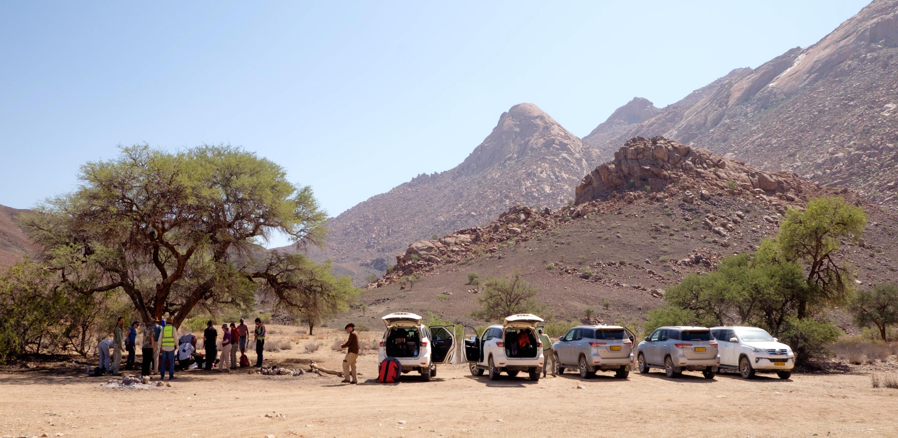 Geologists stop for a shady lunch at the Amis Gorge, Brandberg Complex, Damaraland Alkaline Province, Namibia. Credit: Charlie Beard.