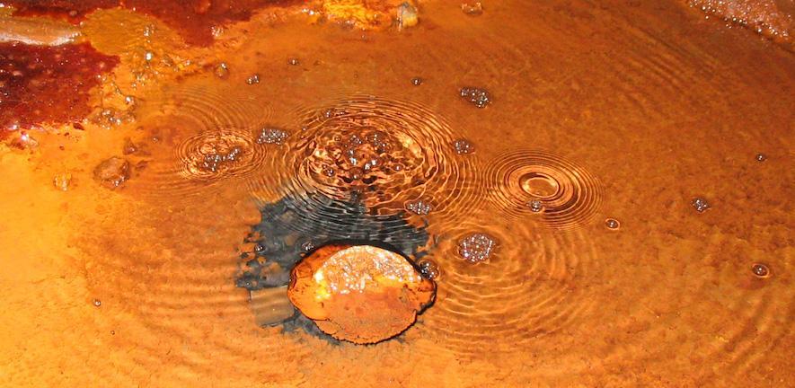 Methane Bubbles in Soudan Mine, Minnesota, USA. Credit: Jon Telling, University of Toronto Image of rust brown water with bubbles rising