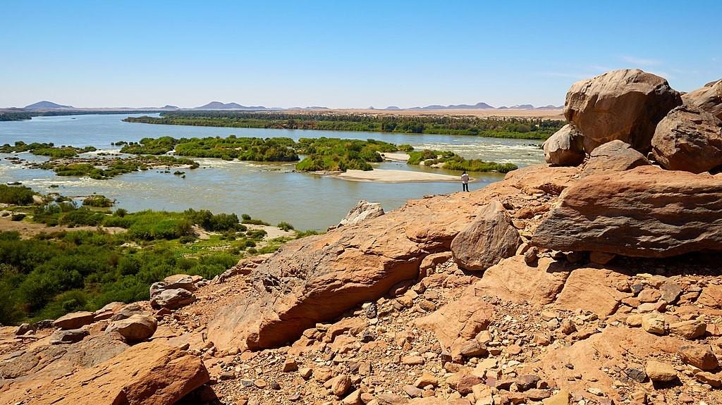 Photo showing a man standing beside the River Nile