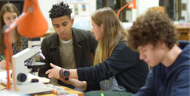 Image of students looking under a microscope