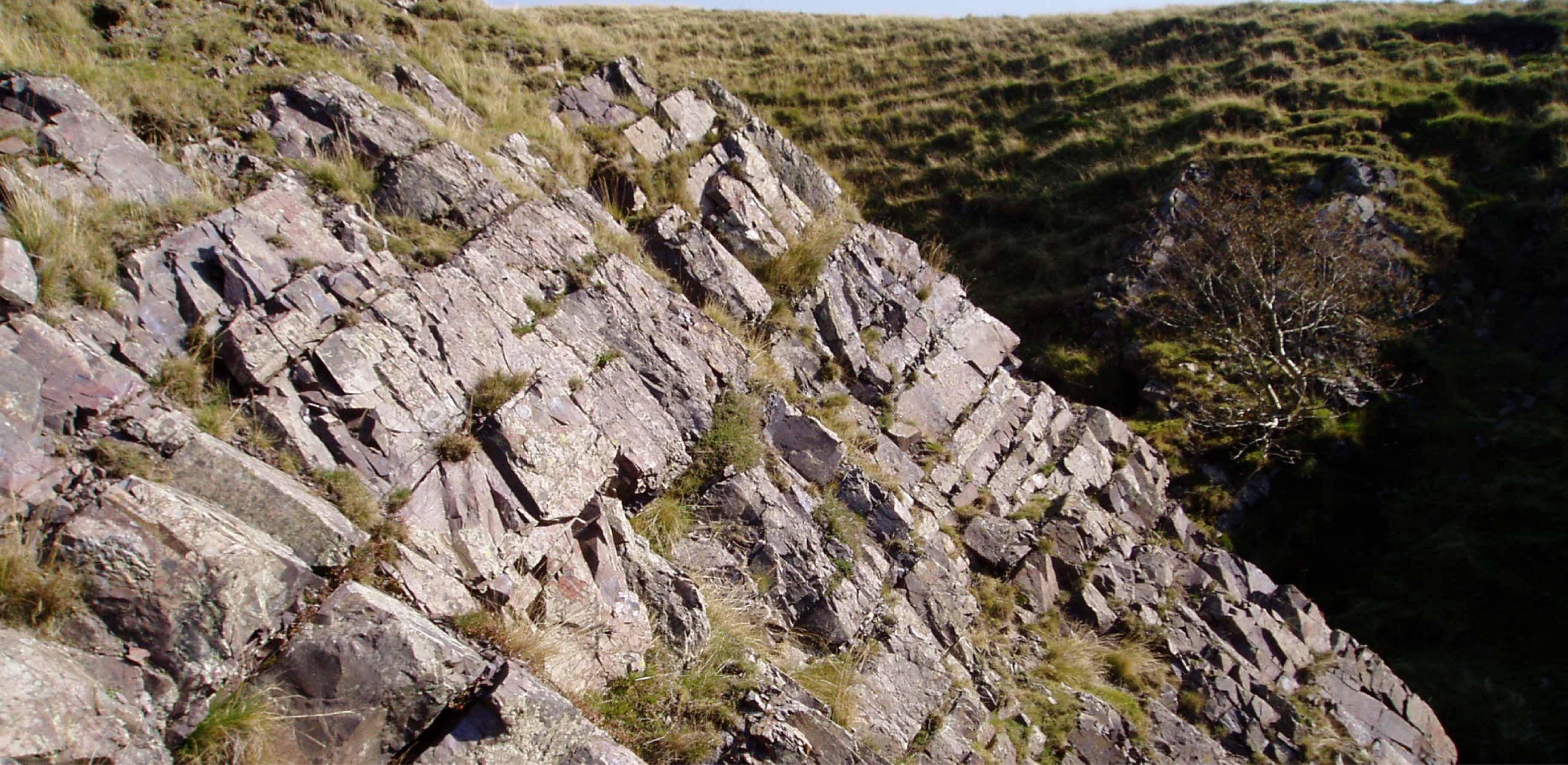 Photos shows stripey grey rocks in layers running horizontally