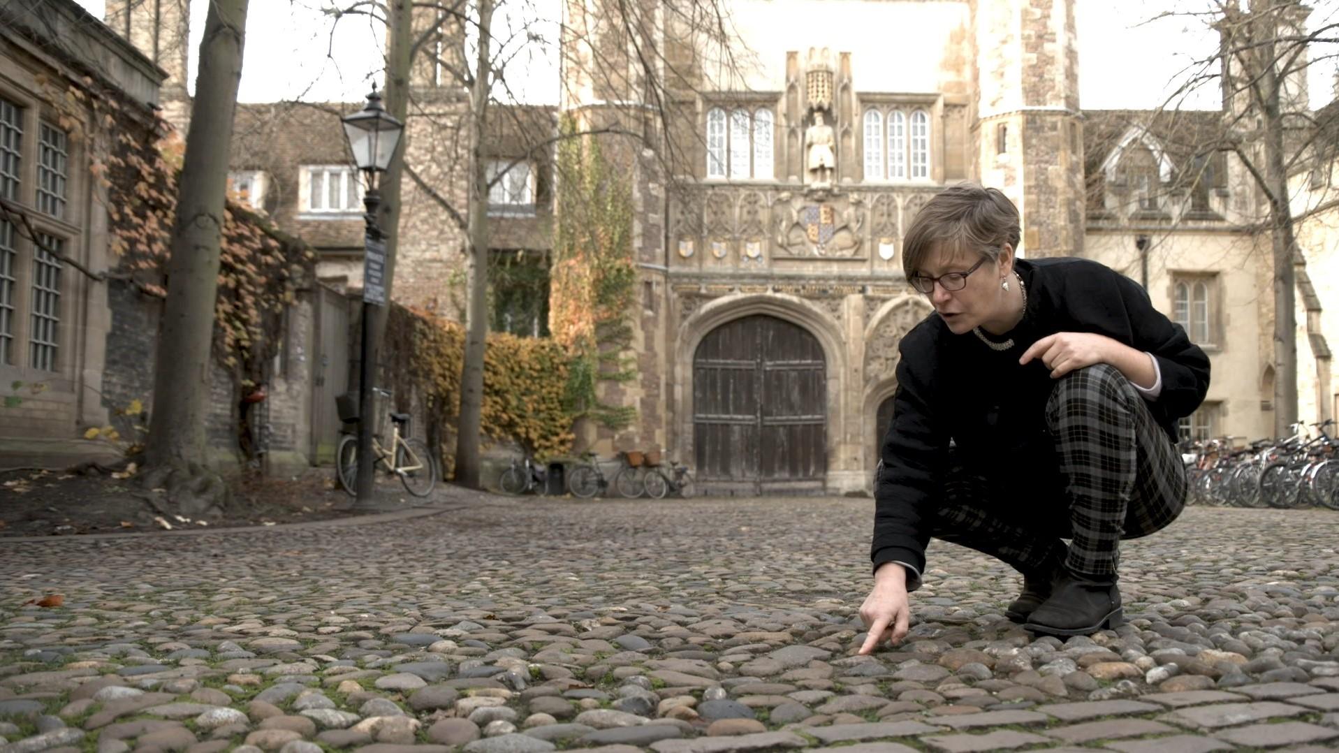 Photo of Professor Holness pointing down at cobbles