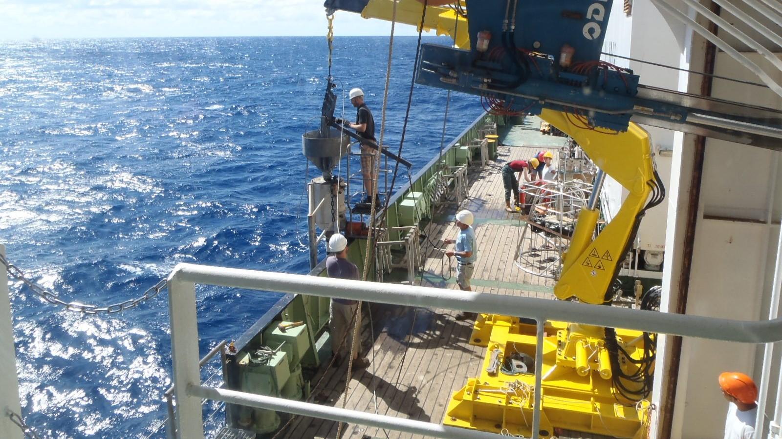 Photo of ocean drilling ship at sea, lowering down coring device to capture sediment