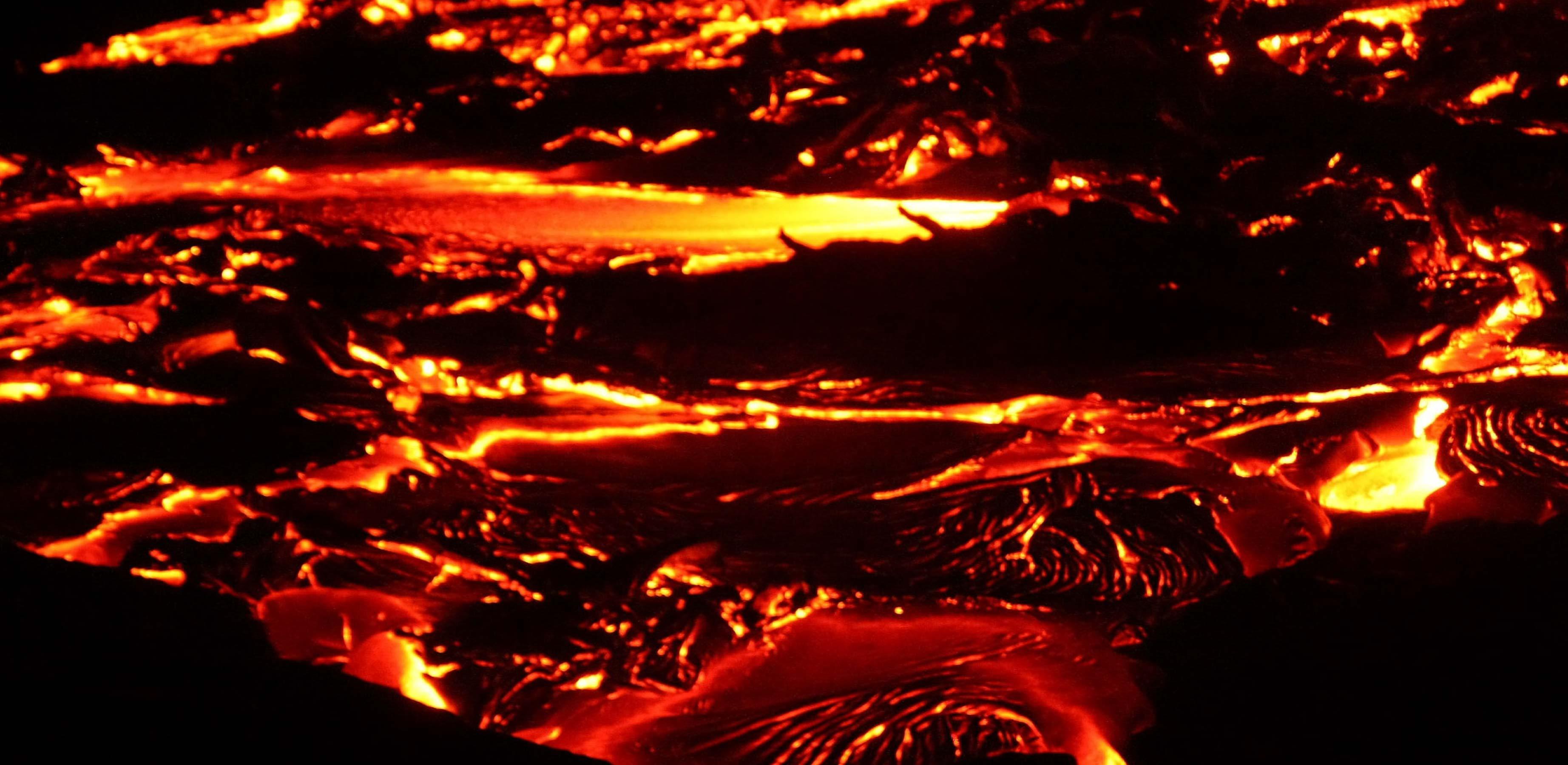 Photo of incandescent lava flow taken at night.
