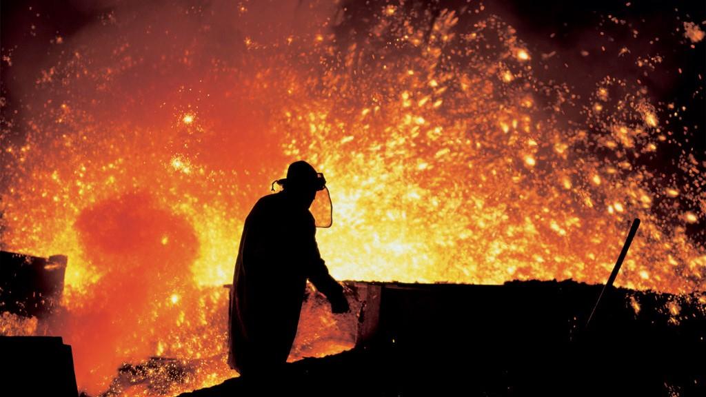 Photo of a person working at a blast furnace